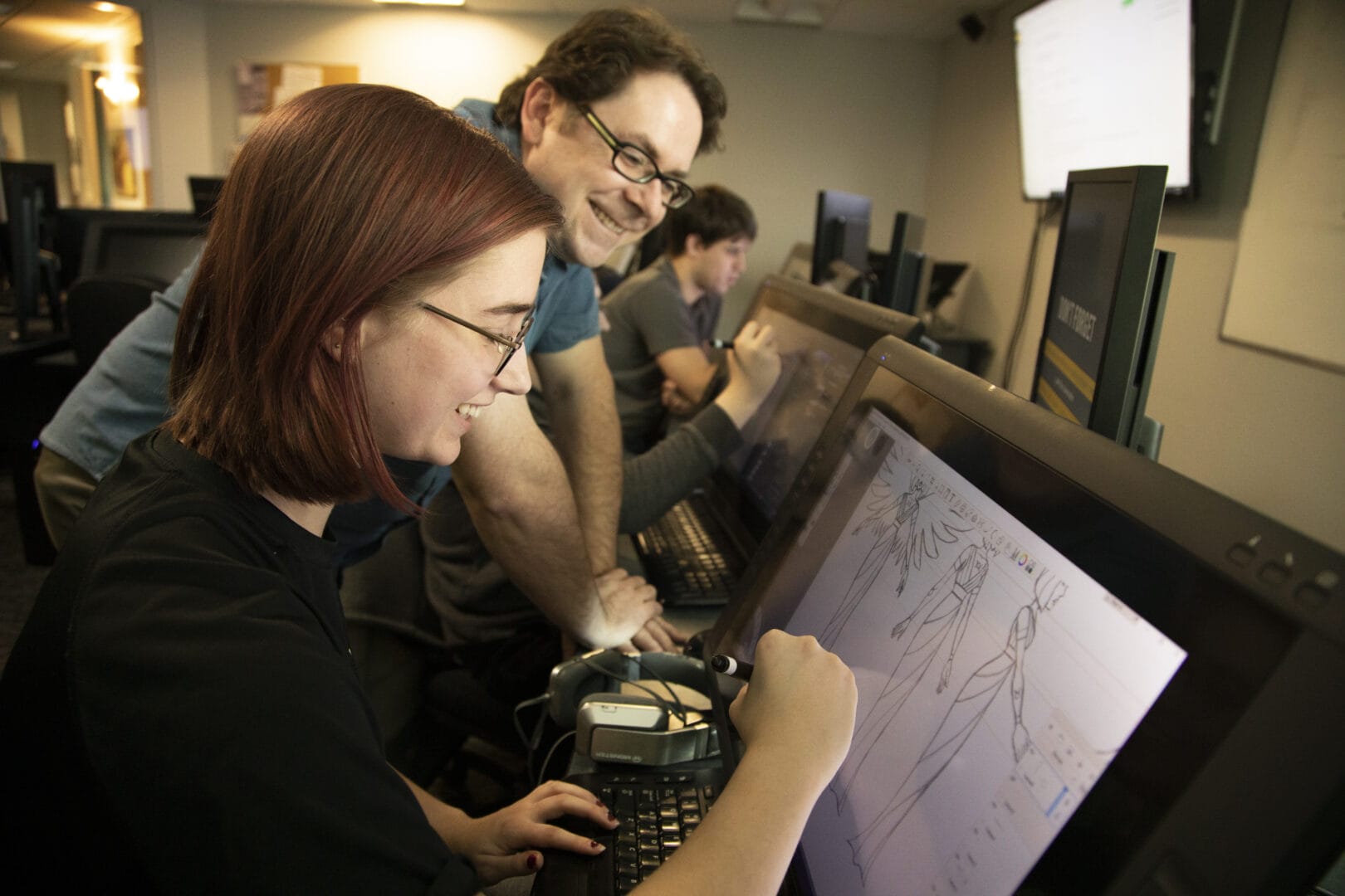 Animation student works with Department Head, Sean Ridgway on a project.  