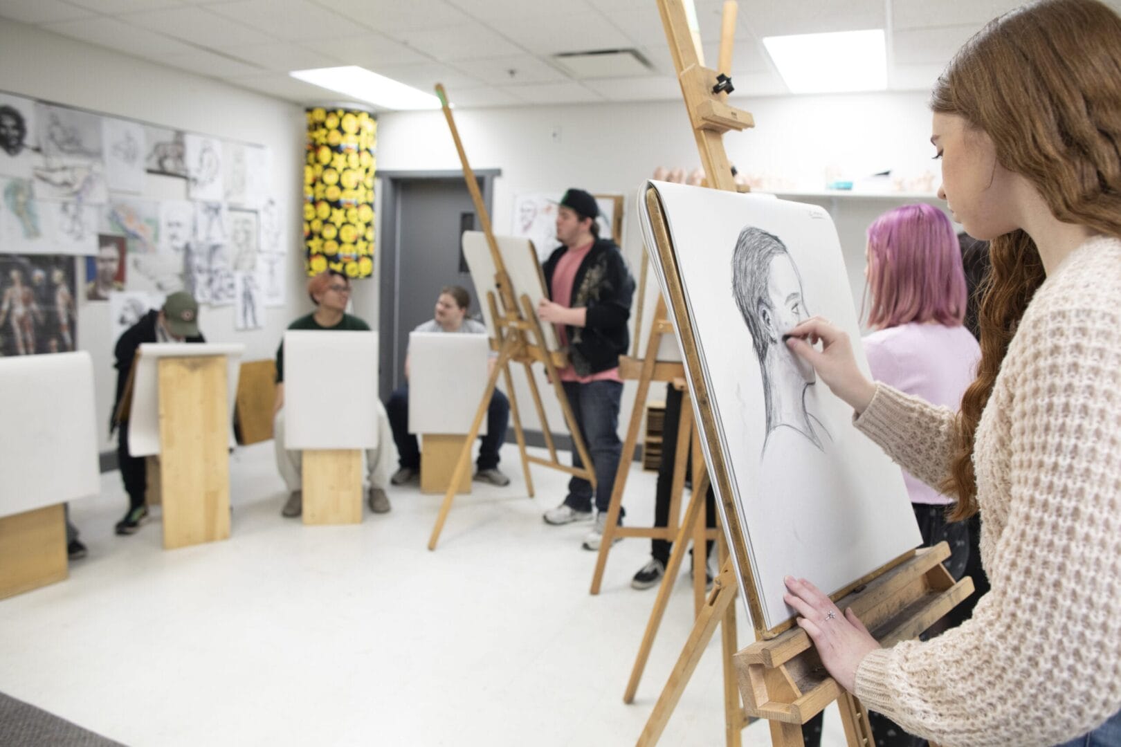 Animation students learning life drawing with a model. 