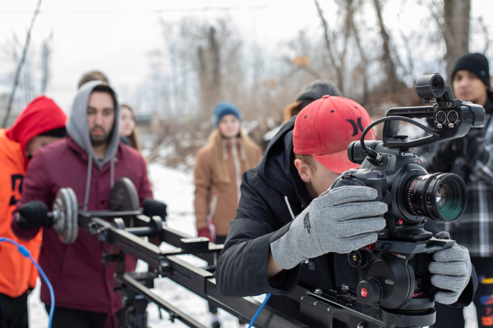 Students behind film camera on location.